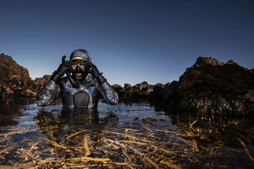 Dr Roberta D'Archino diving amongst seaweed.